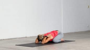Abi Carver demonstrating a Child's Pose Variation with triceps stretch